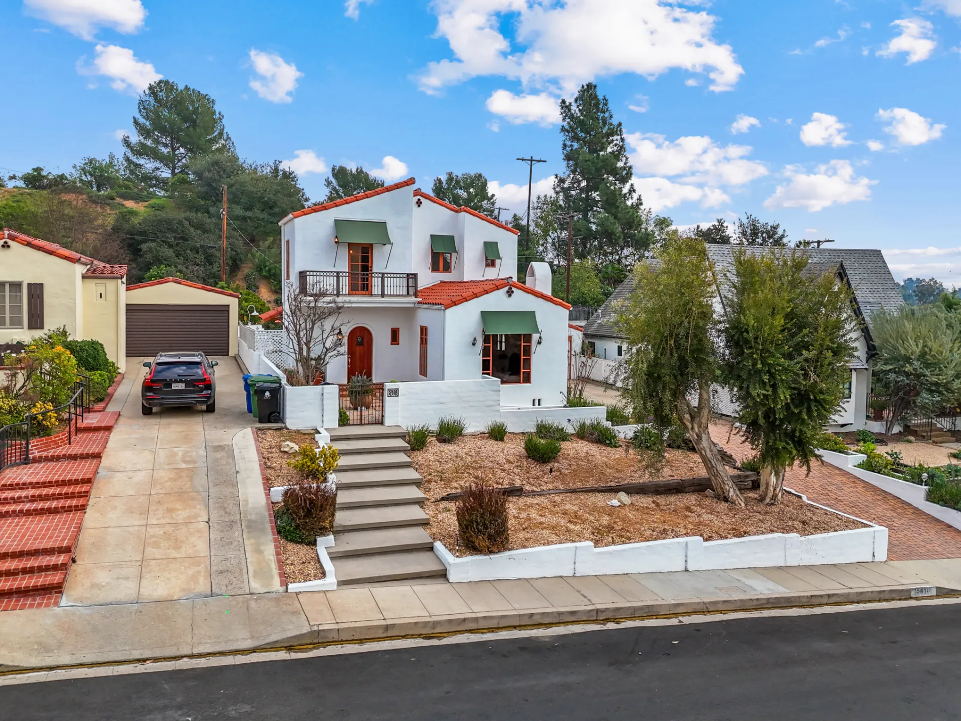 Spanish-style white stucco LA home with red tile roof and front garden